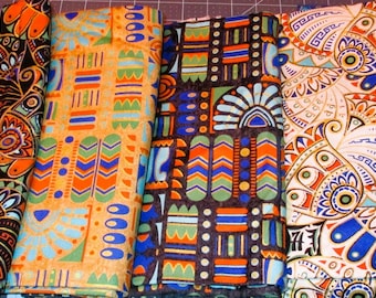 May include: Six fabric swatches with geometric patterns in shades of blue, orange, and gold. The patterns include stylized flowers, chevrons, and geometric shapes.