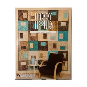 May include: A quilt pattern with the words "HAPPY HOUR" and "relax and enjoy" in a square design. The quilt has a patchwork design with squares of teal, brown, and tan. A brown armchair and small table with a vase and cup are in the image.