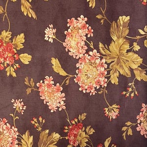 May include: A dark brown fabric with a floral pattern. The flowers are pink, red, and yellow. The leaves are a light brown colour.