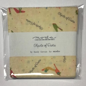 May include: A cream-colored fabric square with a repeating pattern of green and red high-heeled shoes and the text "Objects of Desire" in black. The fabric is designed by Sandy Gervais for moda.