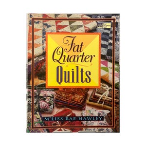 May include: The cover of a book titled "Fat Quarter Quilts" with a yellow and orange design. The cover features a variety of colourful quilt patterns and stacks of fabric. The author's name, M'Liss Rae Hawley, is also visible.
