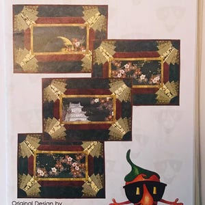 May include: A quilting pattern for placemats called "Inner Beauty" by Chili Pepper Quilt Patterns. The pattern features a traditional and paper piecing technique. The image shows three placemats with different designs, each with a dark background and gold accents.