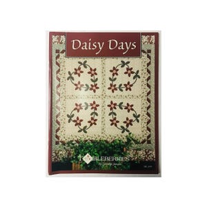 May include: A quilt pattern booklet titled "Daisy Days" by Thimbleberries by Lynette Jensen. The cover features a quilt design with a white background and red and green floral motifs.