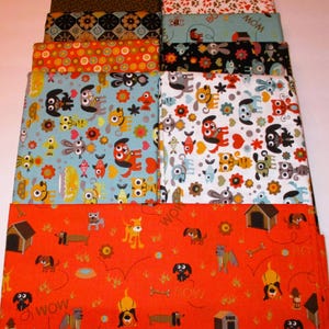 May include: A stack of 10 fabric squares featuring a variety of dog-themed patterns. The patterns include dogs, bones, houses, and the word "WOW". The fabrics are in shades of orange, blue, brown, black, white, and green.