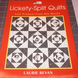 May include: A book titled "Lickety-Split Quilts: Fast Projects from BIG Blocks" by Laurie Bevan. The cover features a quilt with a black and white geometric pattern.