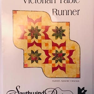May include: A quilt pattern for a Victorian table runner. The pattern features a repeating design of red, green, and yellow flowers on a cream background. The pattern is titled "Victorian Table Runner" and is by Southwind Designs.