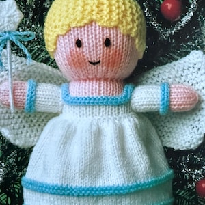 May include: A knitted angel doll with a yellow halo, blonde hair, and a white dress with blue trim. The doll has pink cheeks and arms, and white wings. It is a handmade Christmas ornament.