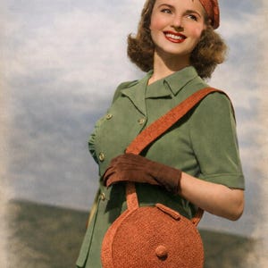 May include: A vintage outfit comprising a green dress, an orange hat, and a round orange handbag. The handbag has a strap and a circular design. The outfit is complemented by brown gloves.