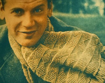 May include: A vintage portrait of a man with dark hair and blue eyes, wearing a textured scarf and a dark coat. The image has a sepia tone, giving it a classic feel. The man is smiling, suggesting a friendly and approachable demeanor.