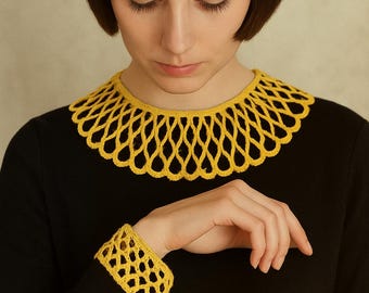 May include: A black dress featuring a yellow crocheted collar and cuff. The openwork pattern of the collar and cuff provides a striking contrast against the black fabric. The yellow colour adds a vibrant touch to the overall design.