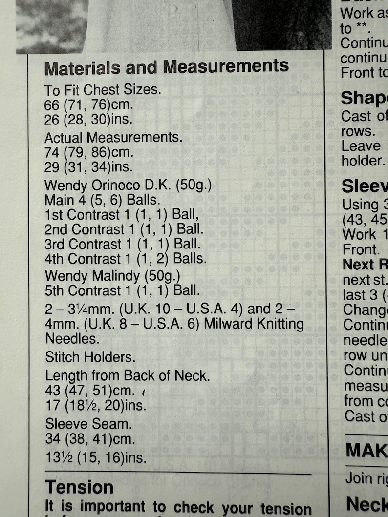 May include: A close-up of a printed page with knitting pattern instructions. The text includes measurements in centimeters and inches, along with details for chest sizes, actual measurements, and yarn requirements. The page also lists needle sizes.