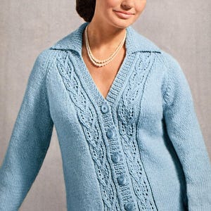 May include: A light blue knitted cardigan with a V-neck and long sleeves. The cardigan features a cable knit design down the front and is fastened with six matching buttons. The collar is a classic style, and the garment appears to be made of a soft, possibly wool, material.