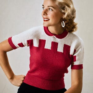 Könnte beinhalten: Ein rot-weißes Kurzarm-Sweater mit geometrischem Muster. Der Pullover hat einen weißen Kragen und Manschetten sowie einen roten Körper mit weißen rechteckigen Formen. Die Frau trägt weiße Creolen und eine schwarze Hose.