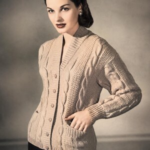 Può includere: Un cardigan beige in maglia a trecce con scollo a V, chiusura frontale con bottoni in tinta, maniche lunghe con polsini a coste e due tasche anteriori. Il motivo della maglia presenta intrecci verticali e pannelli testurizzati.