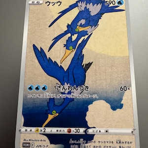 May include: A Pokémon trading card featuring a blue bird-like creature with a yellow beak and white accents. The card has Japanese text and a watercolor-style background. The card is labeled "PROMO E 226/S-P".