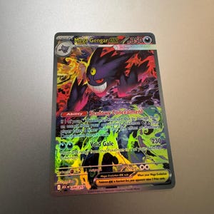 May include: A holographic Mega Gengar EX Pokémon trading card. The card features a purple and black Gengar with a menacing grin, set against a fiery background. The card has text that reads "Shadowy Concealment" and "Void Gale".