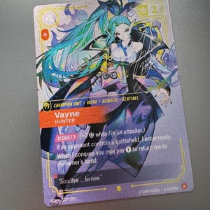 May include: A rectangular trading card featuring a stylized illustration of a character with long teal hair, wearing a dark outfit. The card displays the text Vayne, Hunter, Champion Unit, Demacia, Sentinel, and game mechanics, with a holographic finish.