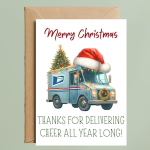 May include: A Christmas card featuring a light blue USPS mail truck decorated with a Santa hat, Christmas lights, and a small Christmas tree. The card reads "Merry Christmas" and "Thanks for delivering cheer all year long!"