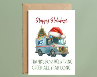 May include: A white greeting card featuring a blue USPS mail truck decorated with colorful string lights, a Christmas tree on the roof, and a Santa hat. The text reads Happy Holidays and THANKS FOR DELIVERING CHEER ALL YEAR LONG!