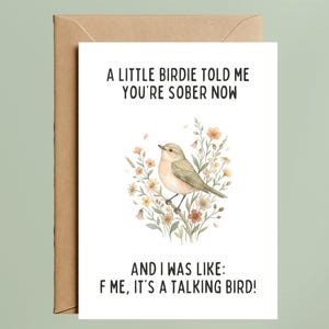May include: A white greeting card with a brown envelope featuring a watercolor illustration of a small bird perched on a branch surrounded by flowers. The text reads: A LITTLE BIRDIE TOLD ME YOU'RE SOBER NOW AND I WAS LIKE: F ME, IT'S A TALKING BIRD!