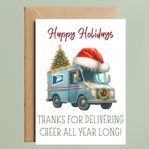 May include: A holiday greeting card featuring a light blue USPS mail truck decorated with a Christmas tree, Santa hat, and string lights. The card reads "Happy Holidays" and "Thanks for Delivering Cheer All Year Long!" on a white background, with a brown envelope.