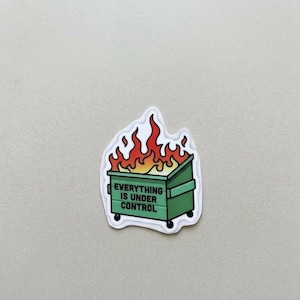 May include: A sticker featuring a green dumpster engulfed in flames. The dumpster has the text "EVERYTHING IS UNDER CONTROL" in white. The flames are red and orange.
