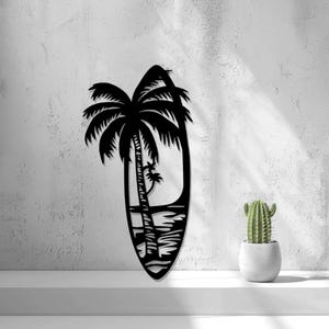 May include: Black silhouette of a surfboard with two palm trees and a sunset scene. The surfboard is shaped like an oval and has a wave pattern at the bottom.