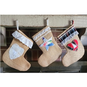 Juego de 3 medias de arpillera color canela natural hechas a mano con apliques de estrella RWB, corazón blanco y cuadros escoceses. Ideales para Navidad, para guardar todo el año y como regalo para cualquier ocasión.