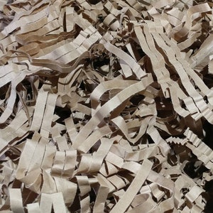 May include: A close-up of brown shredded paper, commonly used as packing material for shipping fragile items.
