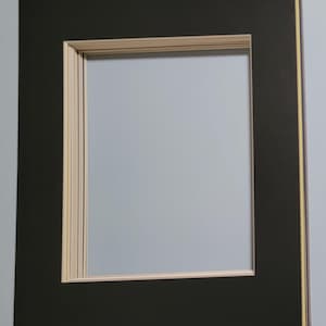May include: A rectangular black picture frame mat with a light beige inner border. The mat has a large rectangular opening in the center. The edges of the mat are layered with a light beige and yellow accent.