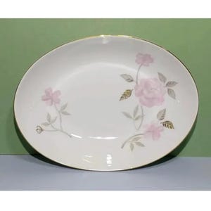 Może przedstawiać: Biała owalna misa do serwowania z pozłacanym brzegiem i delikatnym wzorem kwiatowym z różowymi różami i liśćmi.