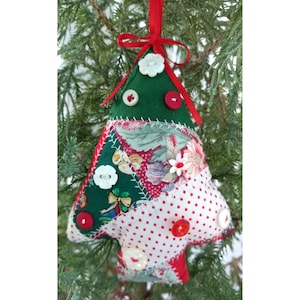 May include: A handmade Christmas tree ornament made from patchwork fabric in red, white, and green. The ornament is decorated with buttons and has a red ribbon for hanging.