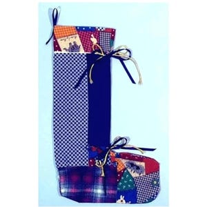 以下が含まれることがあります： ゴールドのリボンとつま先に白いウサギが付いた、青と赤のパッチワークのクリスマスストッキングです。