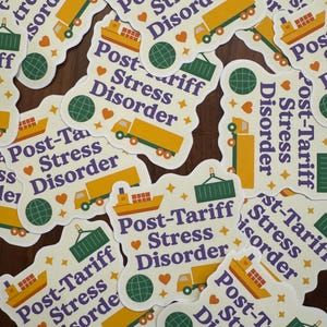 May include: A collection of white stickers with the text "Post-Tariff Stress Disorder" in purple, with illustrations of a ship, truck, and globe. The stickers have a white border and are scattered on a brown surface.