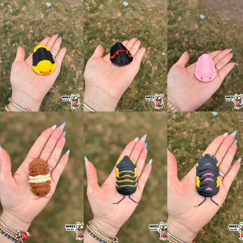 May include: A collection of colorful, stylized trilobite figurines in various colors, including yellow, black, pink, and brown. Each figurine is held in a hand, showcasing the detailed design and vibrant hues. The figurines have a cartoonish appearance.