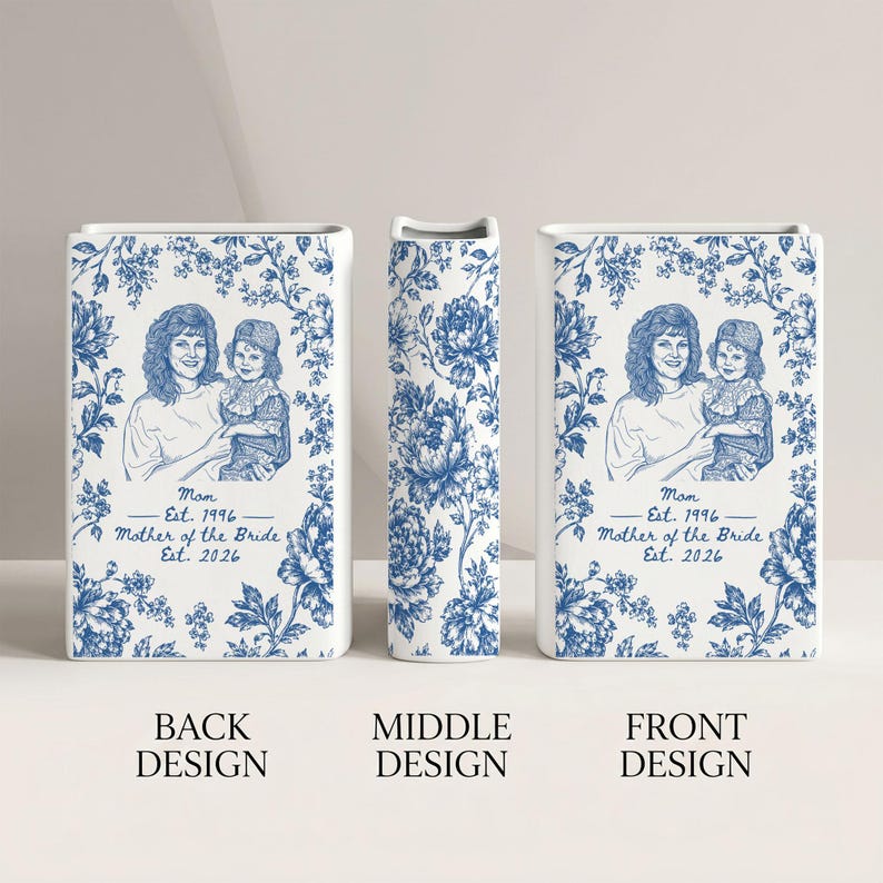 May include: A rectangular white ceramic vase featuring a blue floral pattern. The front and back display a line drawing of a person holding a child with the text: Mom Est. 1996, Mother of the Bride Est. 2026. The middle section shows a floral design.