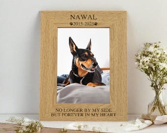 Pode incluir: Um porta-retratos de madeira com uma foto de um cão dentro. O porta-retratos tem as palavras "NAWAL 2015-2025" e "NO LONGER BY MY SIDE BUT FOREVER IN MY HEART" gravadas nele.
