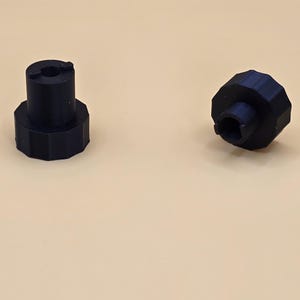 May include: Two black plastic knobs with a center hole. The knobs have a ridged outer edge.