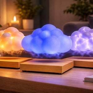 May include: Three levitating cloud-shaped lamps with color-changing LED lights. Each cloud hovers above a wooden base. The clouds emit orange, blue, and purple light, creating a soft, ambient glow. The lamps are on a wooden table.