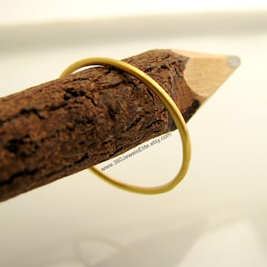 May include: A thin gold ring, shown on a piece of wood, with the website www.360JewelsElite.etsy.com printed on the wood.