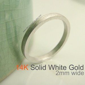 Op de afbeelding: Een 14 karaats massief wit gouden ring die 2 mm breed is. De ring is glad en heeft een gepolijste afwerking.