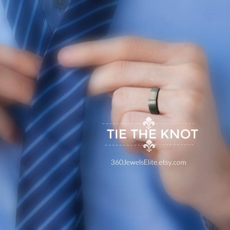 May include: A man's hand wearing a dark gray wedding band. The hand is holding a blue and white striped tie. The text "Tie the Knot" and "360JewelsElite.etsy.com" is below the hand.