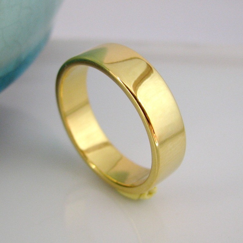 May include: A simple gold wedding band with a polished finish.