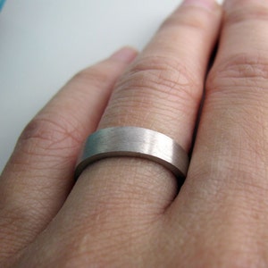 May include: A silver wedding band with a brushed finish.