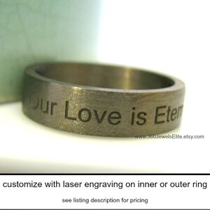 May include: A brushed metal ring with the engraved text "Our Love is Eternal." The ring has a flat, wide band and a matte finish. The Etsy shop URL is visible on the ring. The ring is customizable with laser engraving.