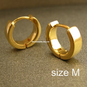 May include: A pair of gold hoop earrings in size M. The earrings are simple and elegant, with a smooth, polished finish.