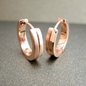 K&ouml;nnte beinhalten: Ein Paar Creolen aus Ros&eacute;gold mit geb&uuml;rsteter Oberfl&auml;che. Die Ohrringe sind schlicht und elegant.