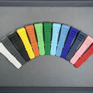 May include: A set of 12 colorful watch bands in various shades of blue, green, yellow, red, and pink. The bands are made of a durable, flexible material and are designed to fit most standard watch sizes.