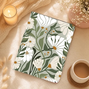 May include: A rectangular notebook featuring a sage green background with a repeating pattern of white daisy-like flowers, dark green leaves, and small mustard yellow accents. The cover has a smooth finish and displays a botanical floral illustration.