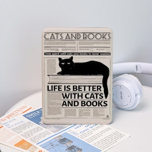 May include: A rectangular, off-white decorative box with a newspaper-style design. The box features the text "CATS AND BOOKS" and "LIFE IS BETTER WITH CATS AND BOOKS". A black cat illustration is also present.